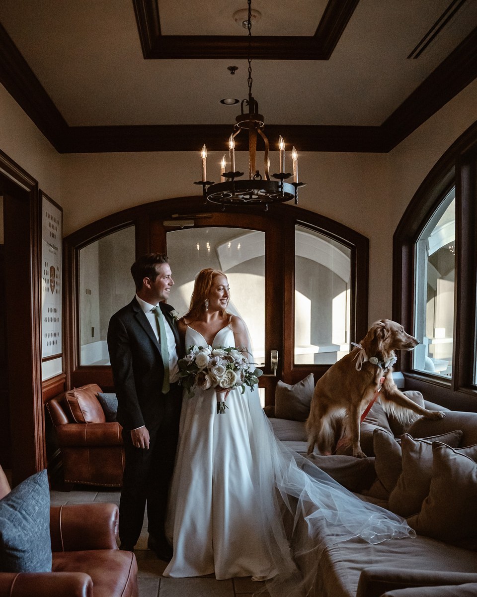 Amanda and Matt in wedding attire with their dog beside them.