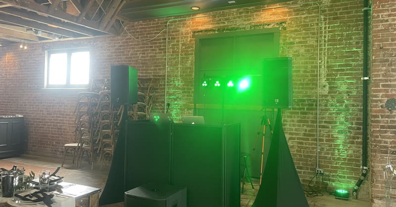 A DJ booth and lighting rig set up in an empty venue before doors.