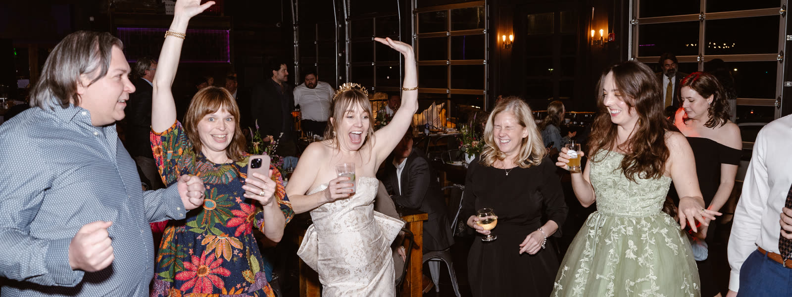 Guests dancing under warm lighting at a reception.