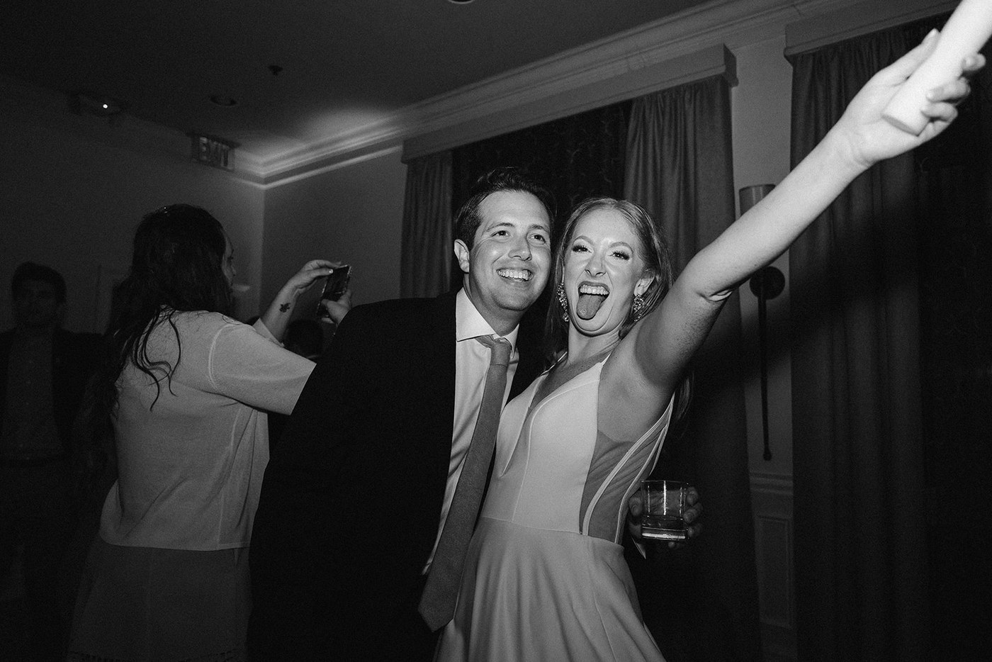 A bride cheering with guests at a wedding reception.