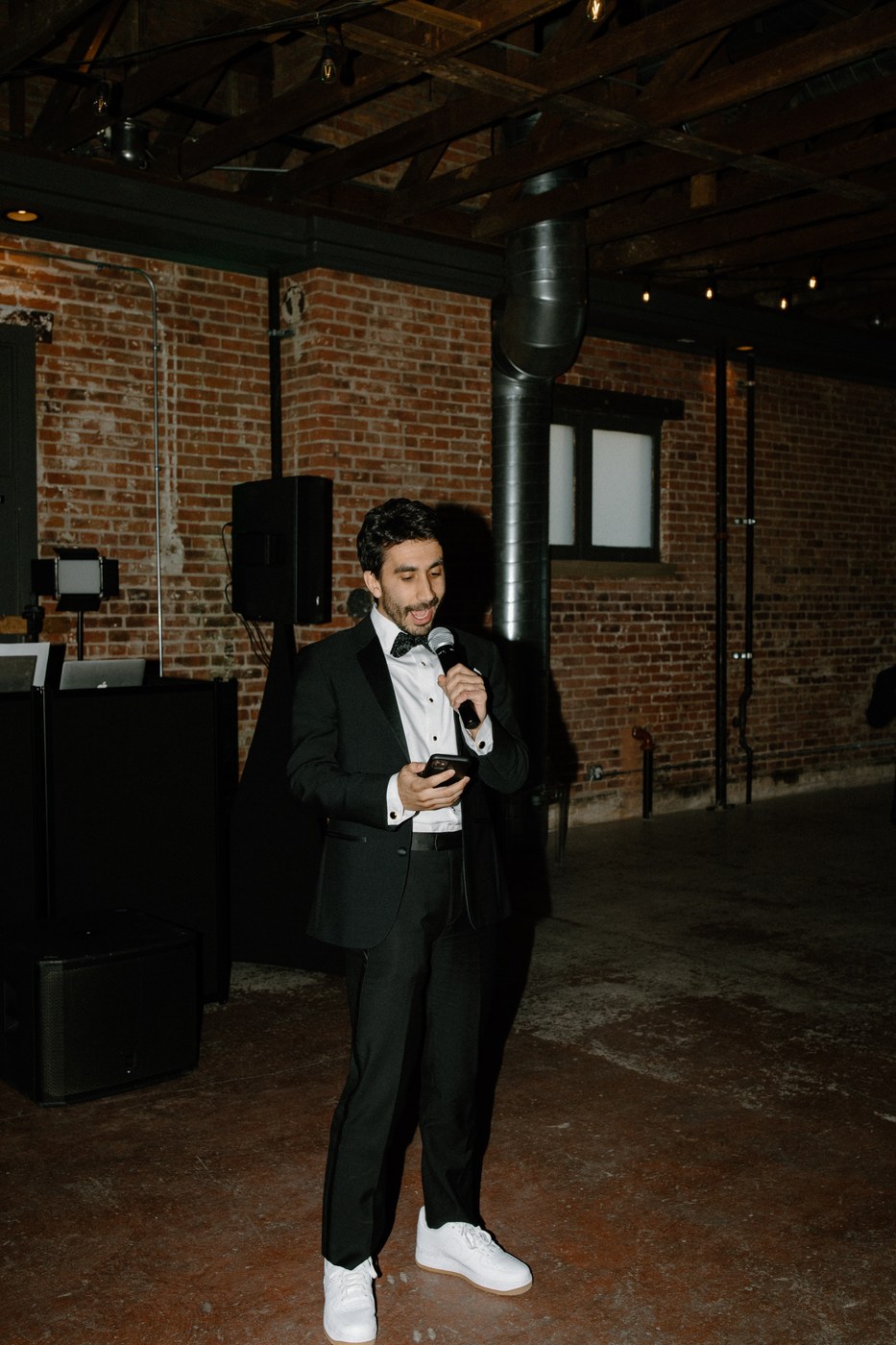 An event host holding a microphone in a reception venue.